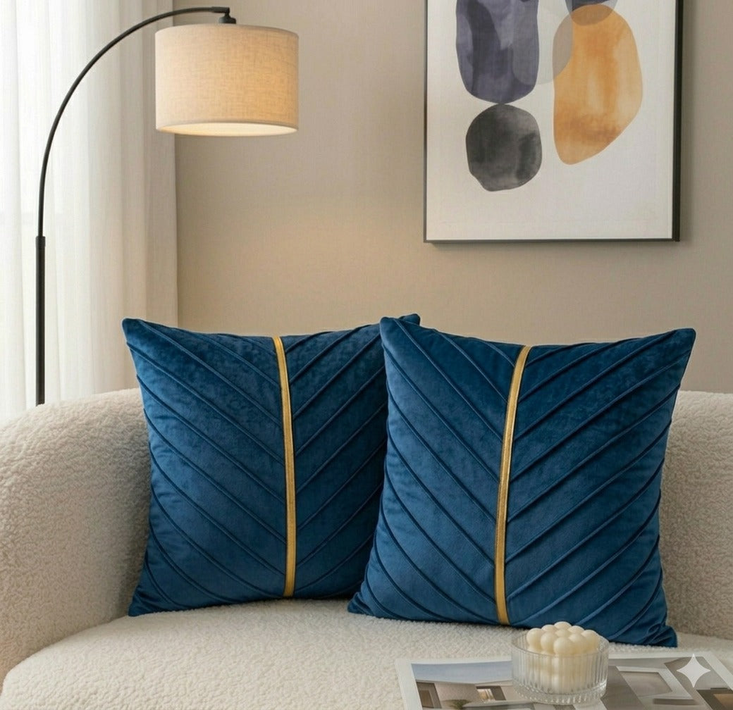 Navy blue velvet cushion covers with gold stripe on a white sofa